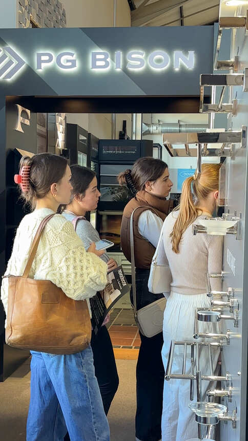 Students looking at bathroom accessories beside a board and finishes display