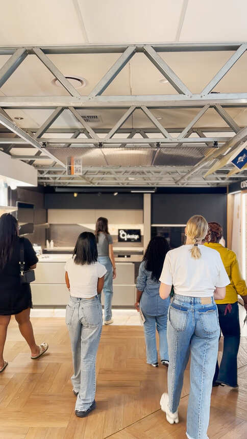 Students walking through the exhibition towards a kitchen display