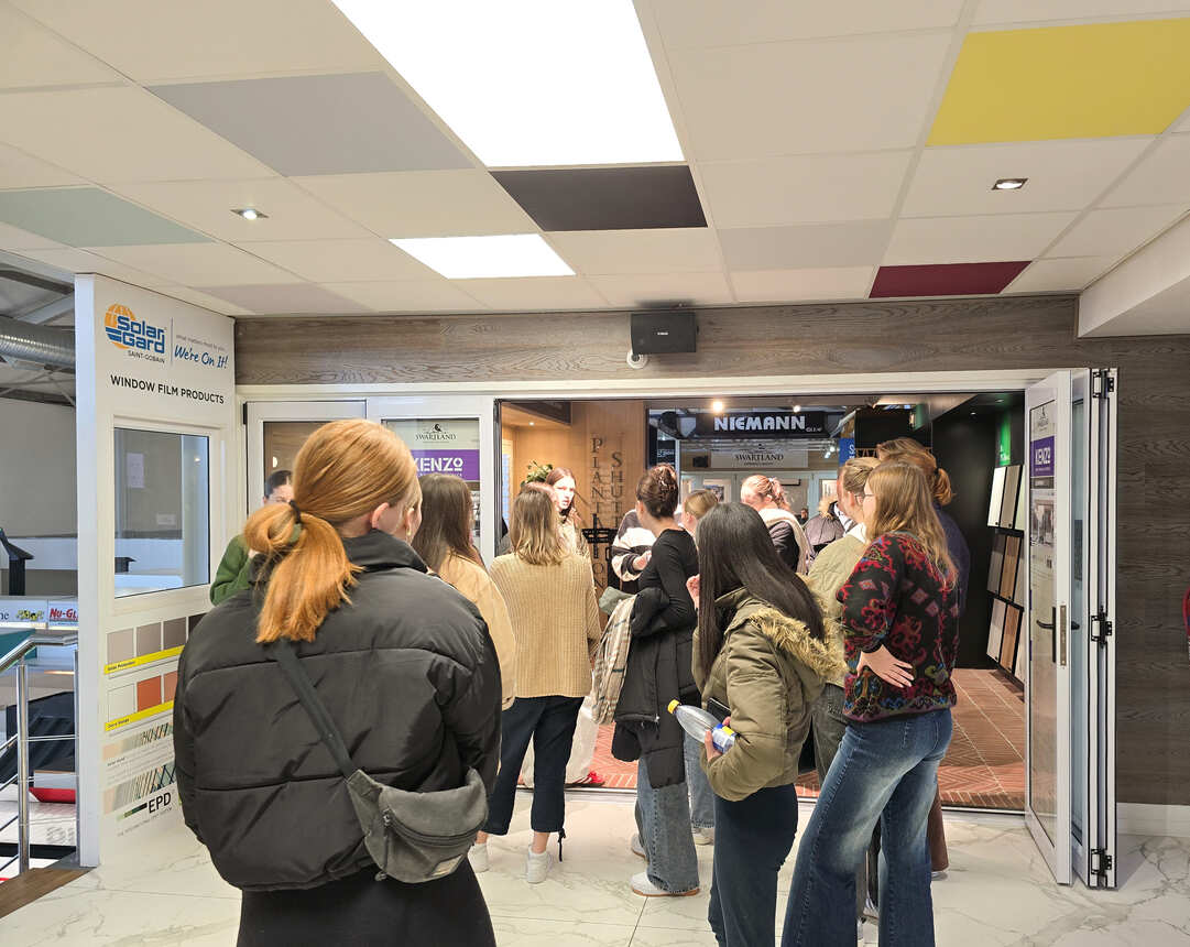 Students gathering at the entrance to a showroom of window, door and shutter displays