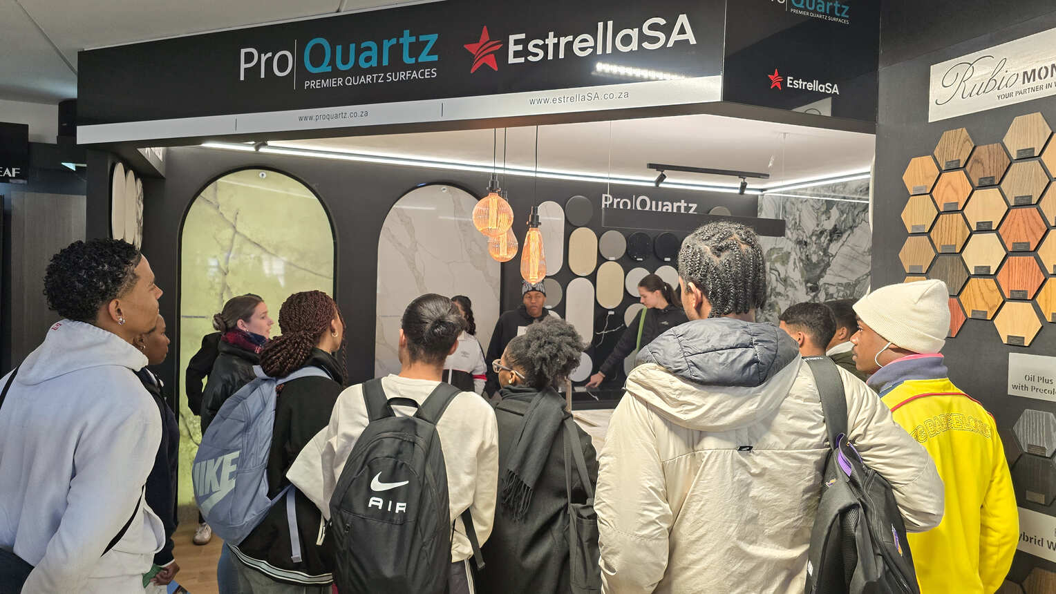 A student group listening to a presentation at a quartz and stone surfaces display