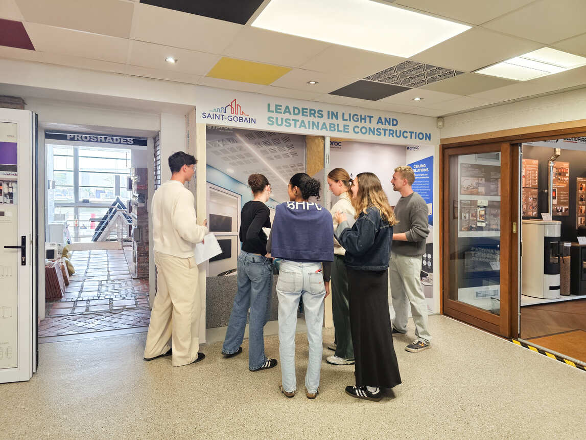 Students reading the information panels at a ceiling and sustainable construction display