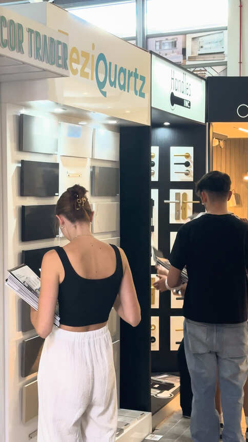 Students carrying product brochures past quartz surface and door handle displays